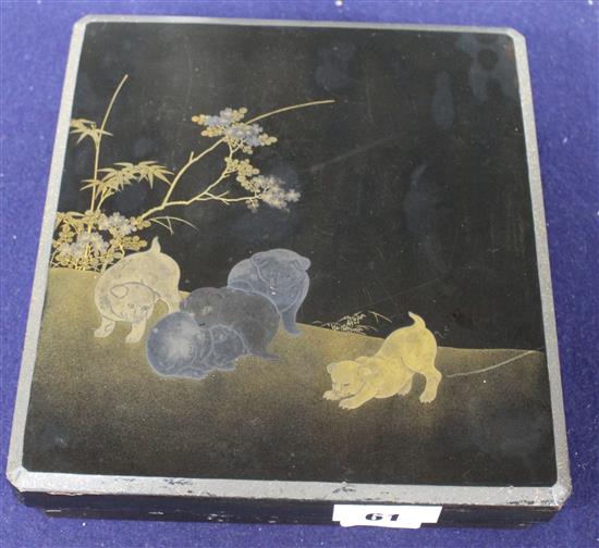 A Japanese Meiji lacquer writing box, the lid decorated with five puppies playing in a garden, underside of the lid with bird perched b